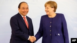 Thủ tướng Nguyễn Xuân Phúc (trái) bắt tay Thủ tướng Angela Merkel tại cuộc họp thượng đỉnh G-20 ở Đức vào tháng 7/2017.